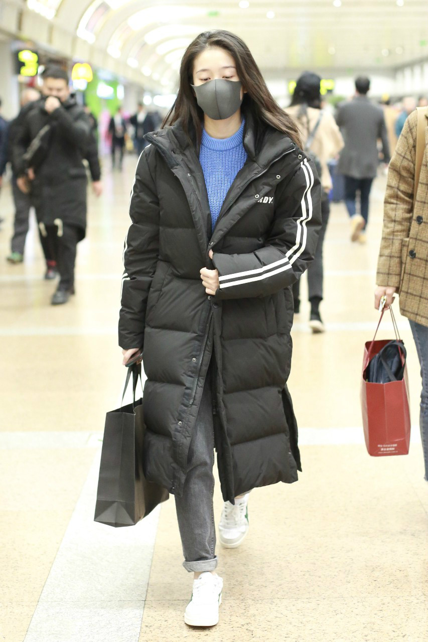 张雪迎戴黑色口罩穿黑色长款羽绒服现身机场,穿着非常保暖又时尚