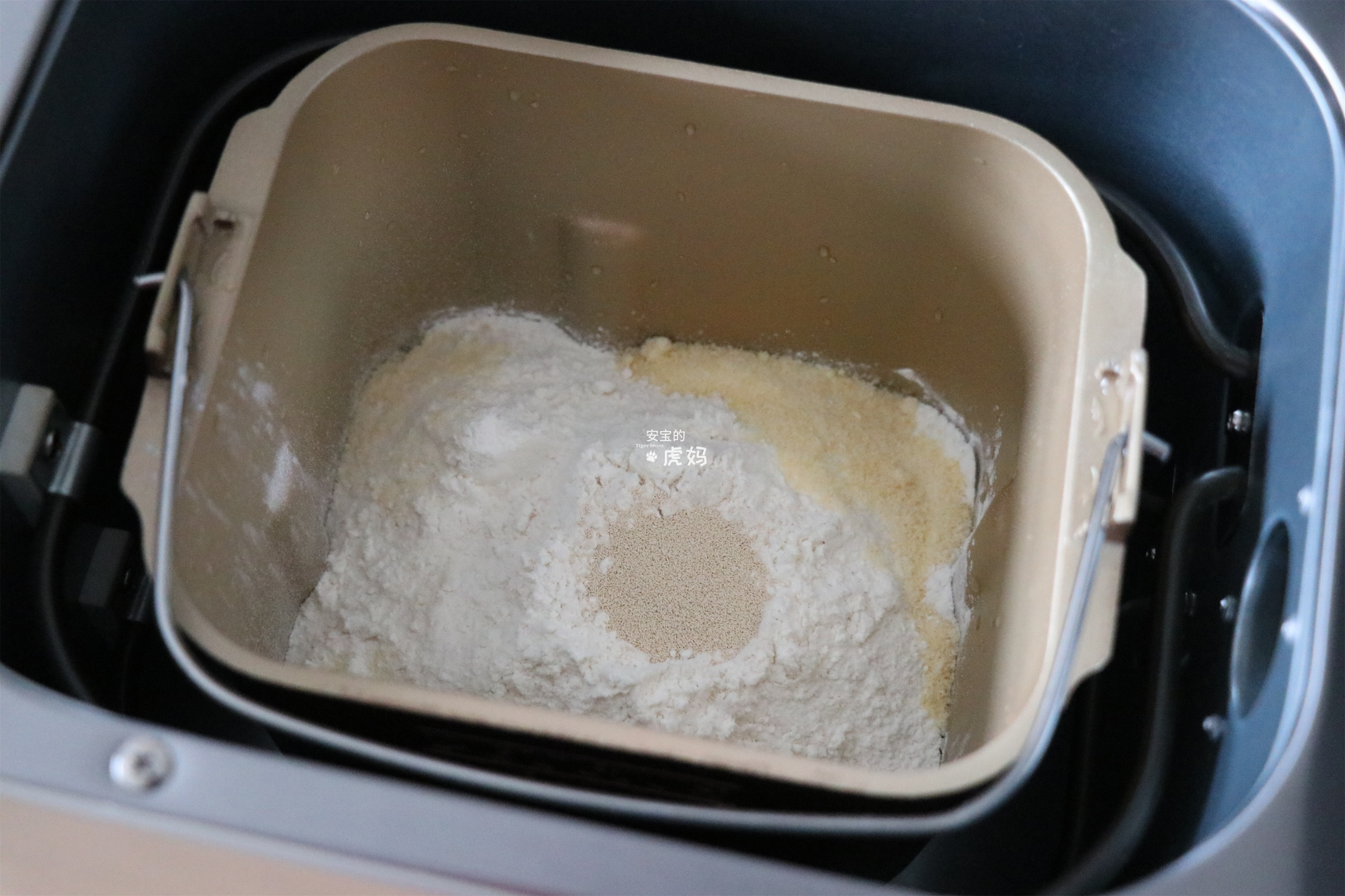 选择面包机的和面程序开始揉面,揉面程序结束后放入黄油,继续选择揉面