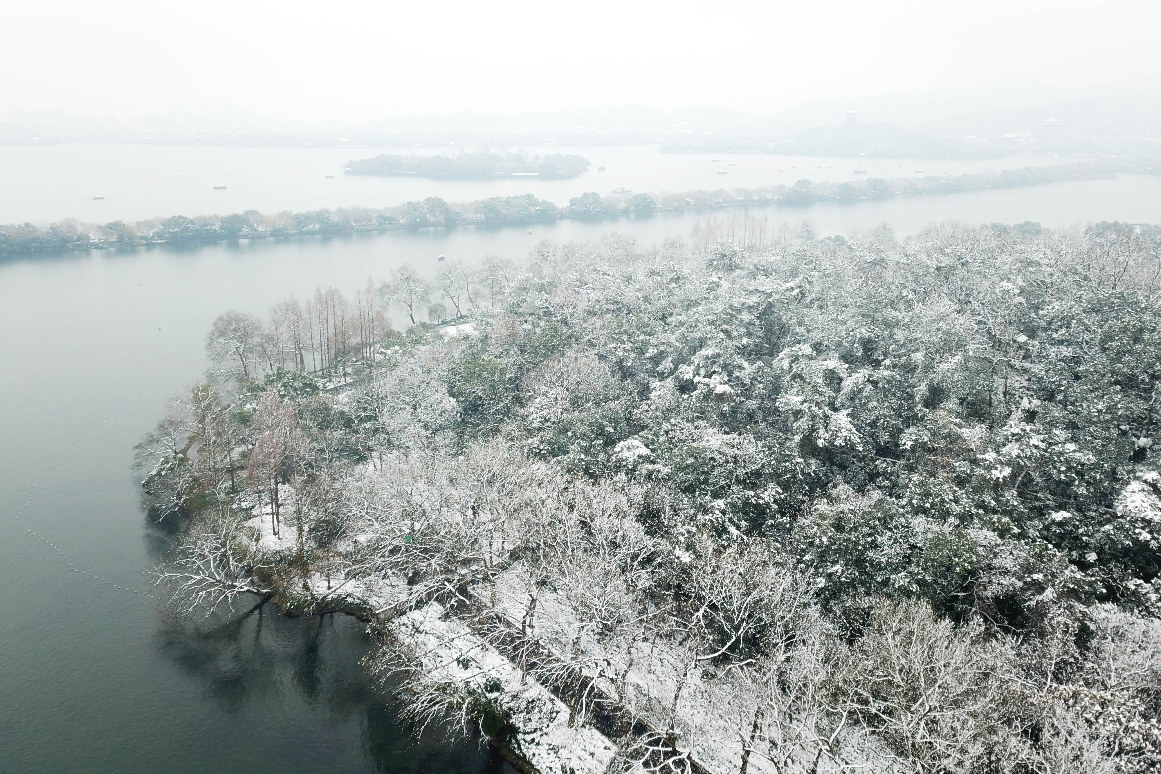 12月31日无人机拍摄的西湖景区杨公堤附近的雪景,远处是苏堤和湖心岛.