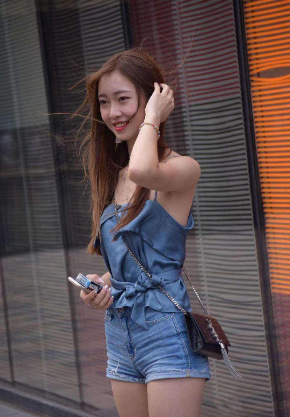 街拍:小姐姐穿蓝色吊带配短裤,身姿窈窕,眉清目秀,一笑倾城