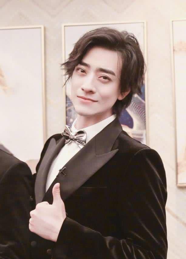 这张照片中的郑云龙医生黑色西装,对着镜头竖起大拇指,看看他那侧脸