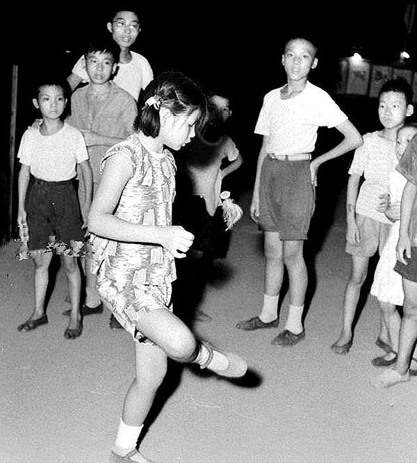50年代城市孩子的生活:穿着白衬衣的少年,踢毽子的小