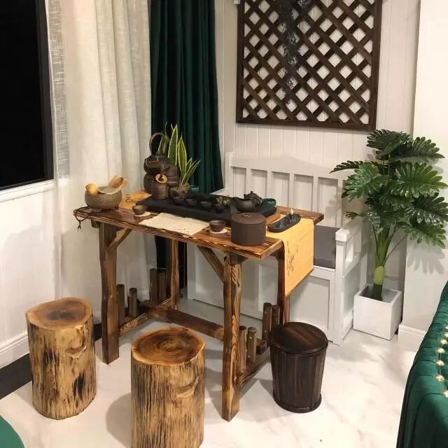 阳台左边设计成茶室,防腐木桌子搭配两个木桩,晒着太阳与朋友在一起喝