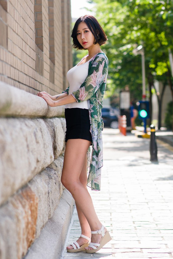 一个穿高跟凉鞋搭配短裤的短发知性美女