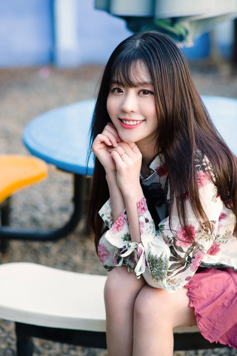 休闲椅子上一个穿雪纺衫和百褶裙的优雅美女