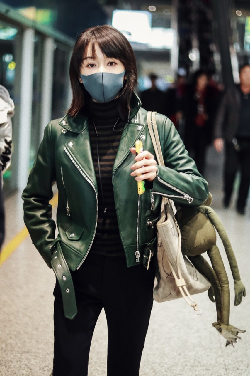 王子文机场街拍,绿色小皮衣搭配黑色喇叭裤潇洒帅气,超大公仔可爱十足