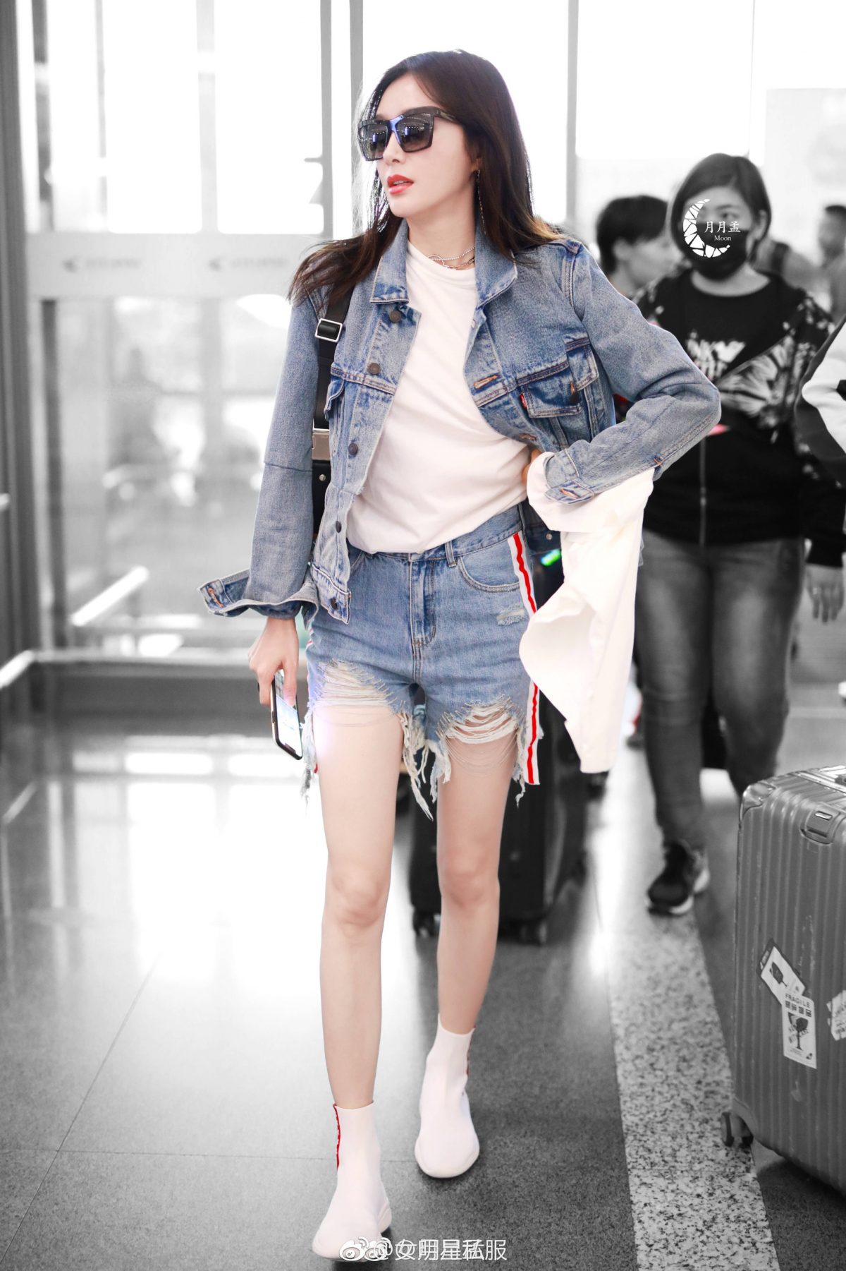 日前她以一身牛仔装现身机场,破洞牛仔短裤下一双白色的普拉达袜子鞋