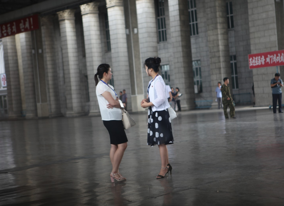 图为朝鲜平壤火车站,两名微胖的朝鲜女导游在站台上.