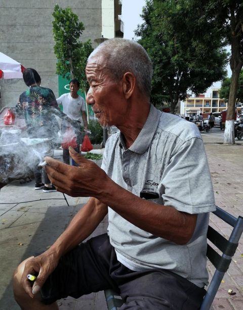 76岁老人赶集卖百货,一天挣不到30元钱,省吃俭用抽旱烟