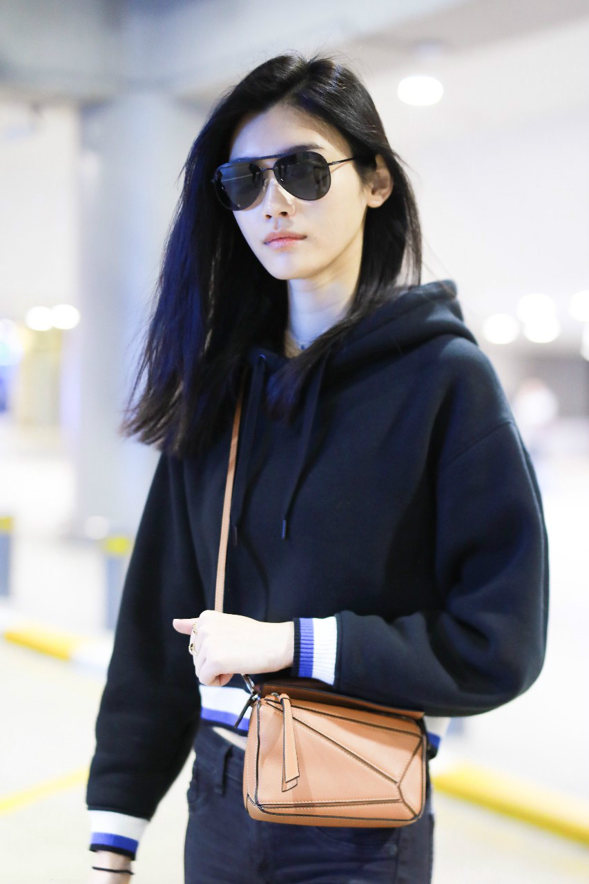 奚梦瑶戴墨镜穿黑色卫衣搭配黑色裤子现身机场,皮肤白皙笑容灿烂