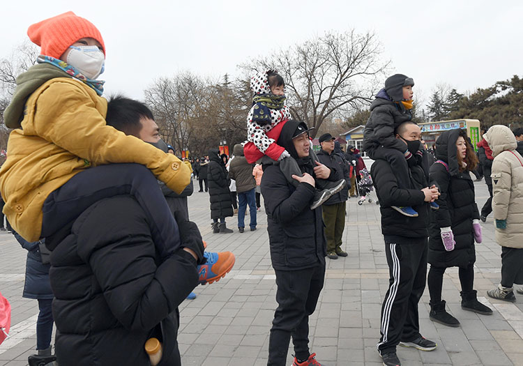 孩子们纷纷骑在父亲的肩膀上看演出.