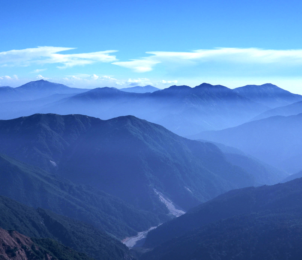 瀑布从山间流下,很多山重叠在一起,眼前的这处景色很美