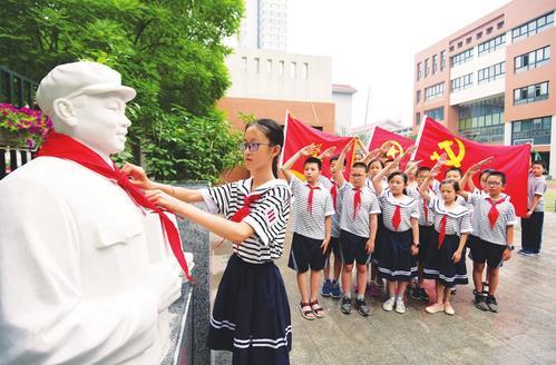 少先队员为雷锋雕像佩戴红领巾 增强孩子社会责任感