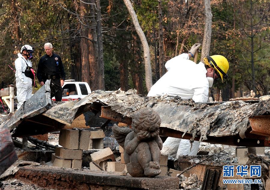 11月19日,在美国加利福尼亚州比尤特县天堂镇,救援人员在山火废墟中