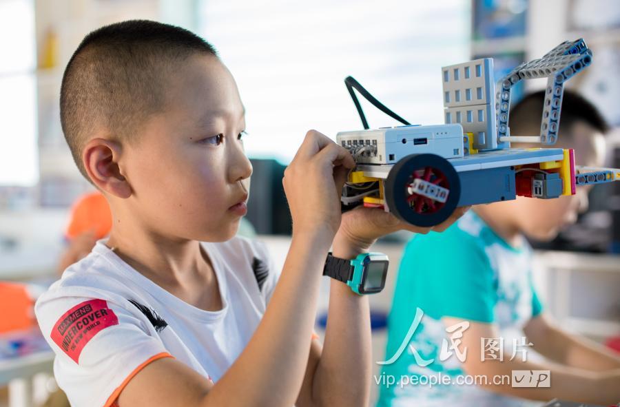2019年7月18日,呼和浩特市玉泉区头道巷小学学生在调试机器人