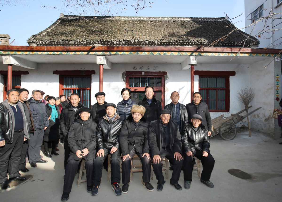 许家印和妻子丁玉梅在老屋前与长辈,小时同伴合影.