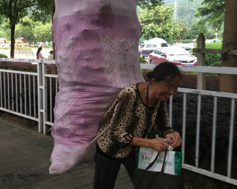 这位老人佝偻着身体,背上是捡来的废旧饮料瓶,一斤可以买3毛钱.