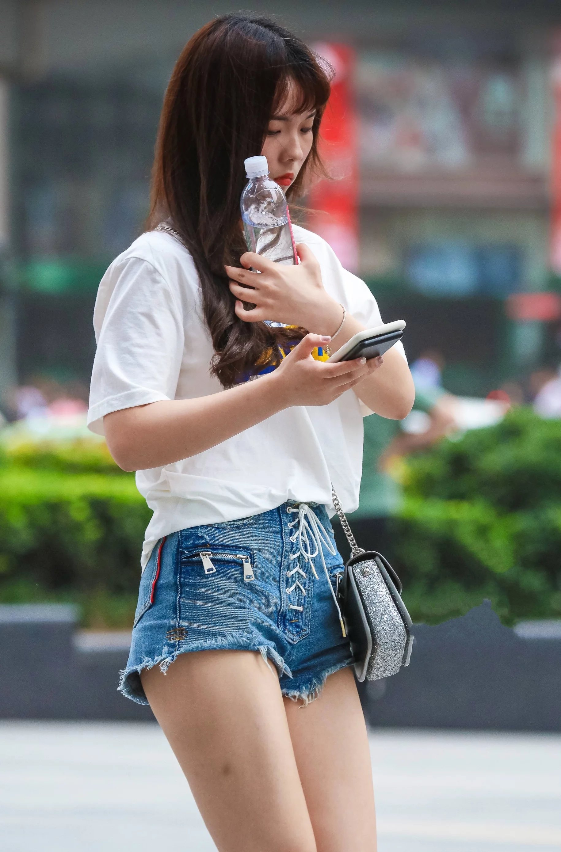 街拍:小姐姐紧身t恤搭配牛仔短裤秀出美腿,一低头很温柔