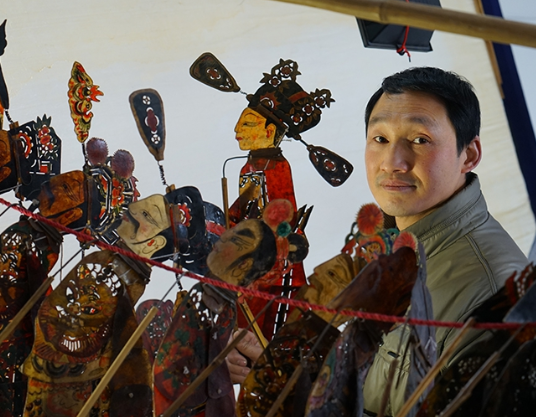 李世宏是一位罗山皮影戏师傅,自幼喜爱皮影戏的他,五六岁时便能把听过