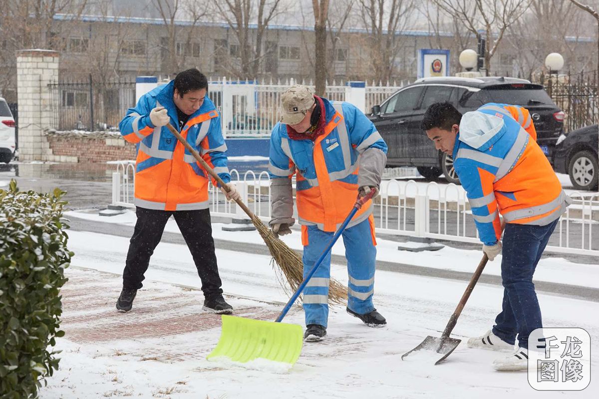 2月14日,北京环卫集团房山公司职工正在进行推雪铲雪作业.