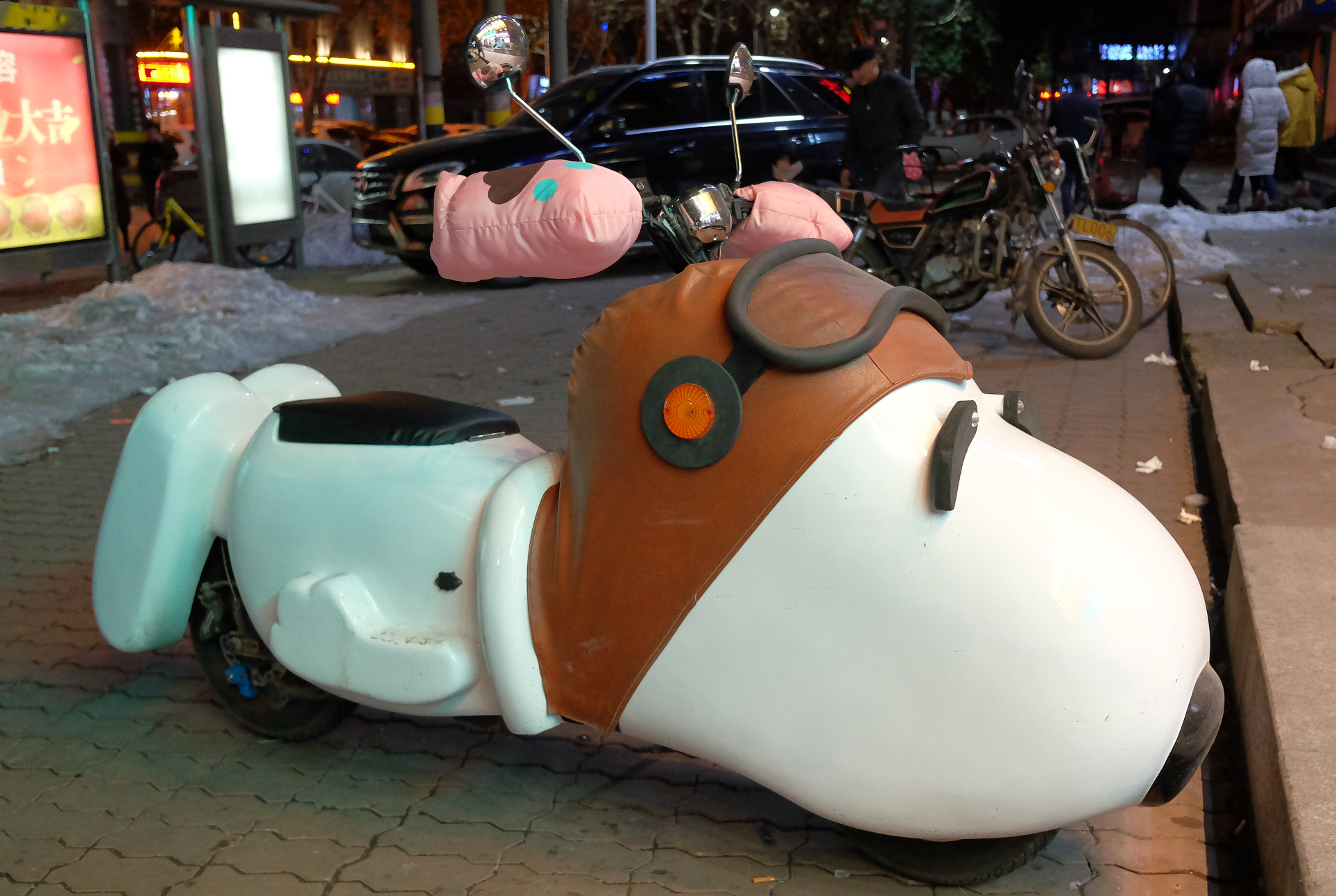 路边停放一辆史努比造型的两轮电动车引来好奇的市民拍照