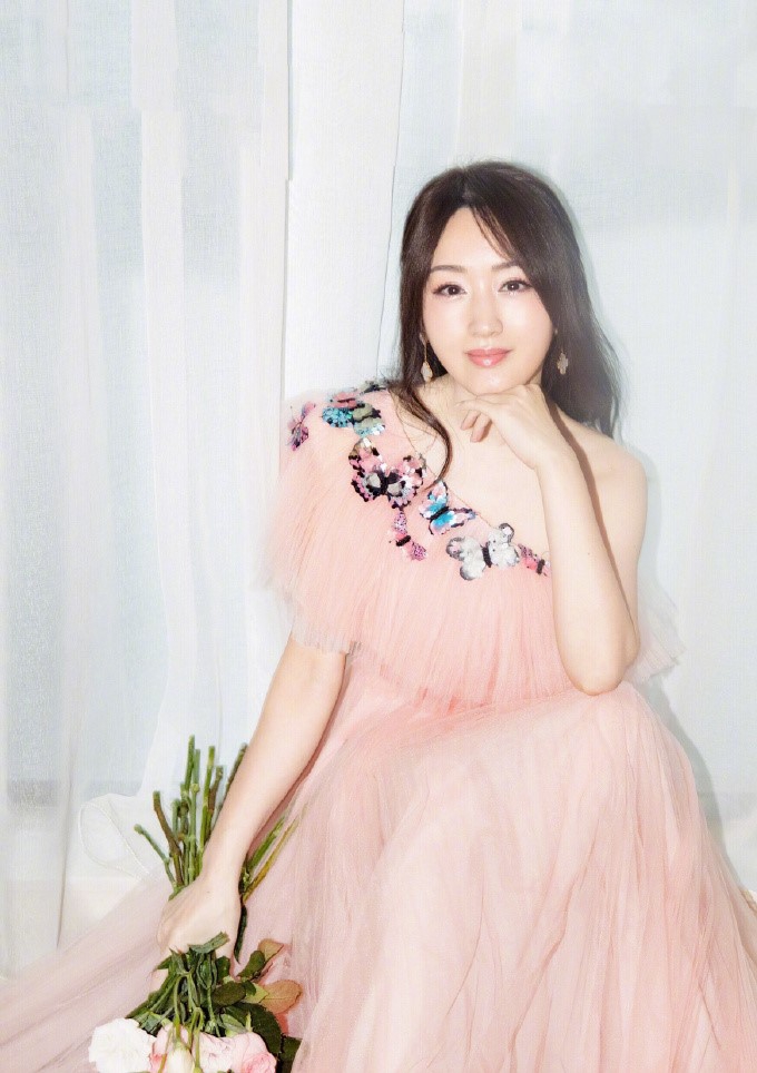 48岁杨钰莹穿粉色礼裙仙气十足,拿玫瑰冲镜头甜笑少女感满满