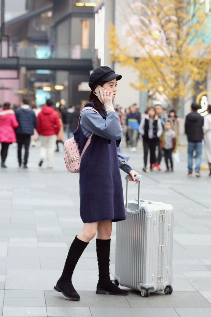 带着行李箱逛街的女孩子,不知道是要去哪里旅游