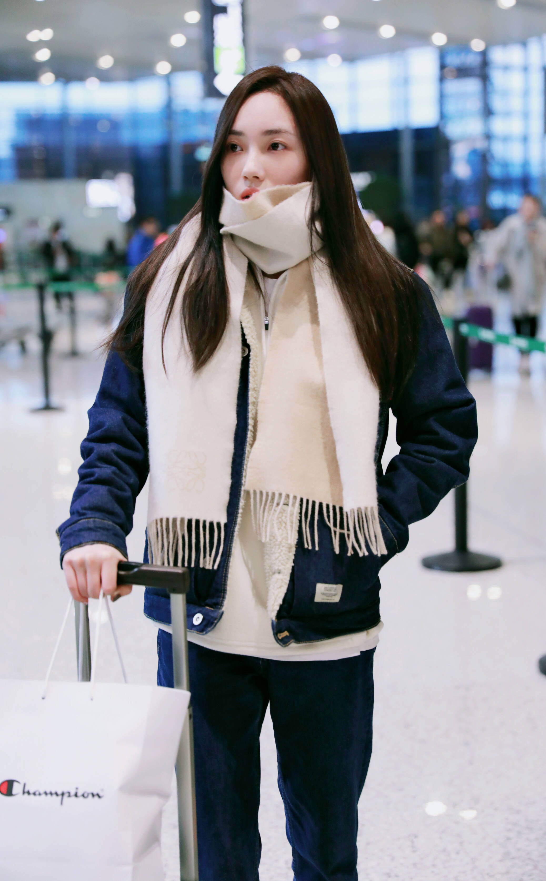 赵嘉敏穿蓝色牛仔衣现身机场,用长围巾遮住半张脸