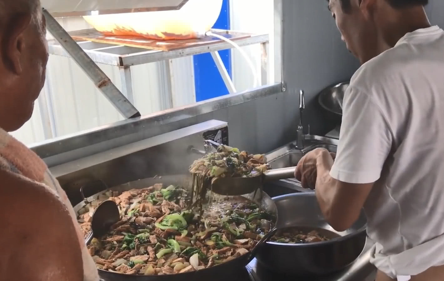 老师傅来工地炒了一大锅菜,实在是太香了,工人纷纷端碗来盛