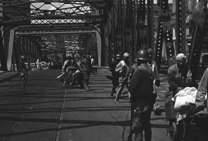 图为:1937年,人们穿过外白渡桥,上海外白渡桥上的日军.