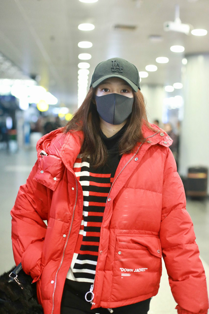 关晓彤穿红色羽绒服搭配黑裤子现身机场,戴黑色棒球帽和口罩遮面