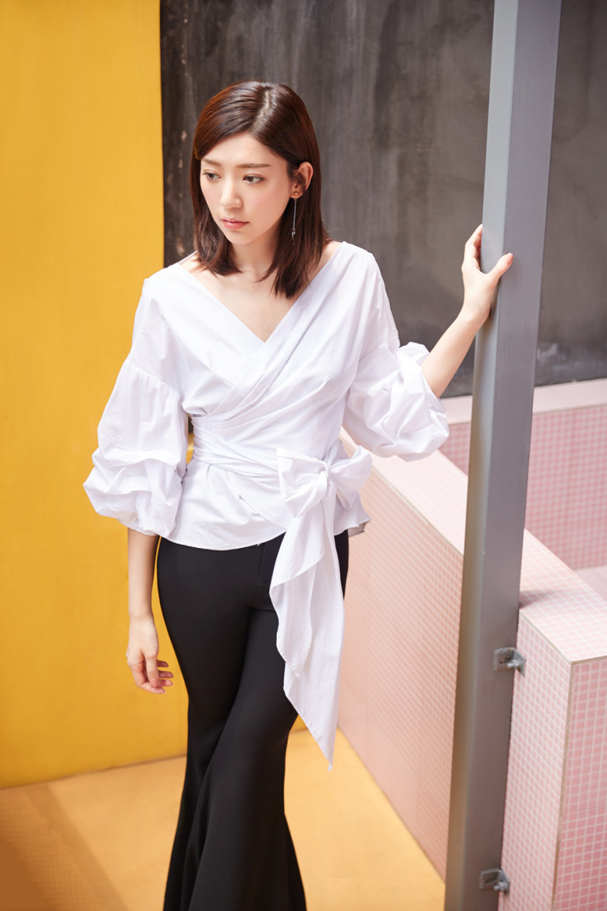 郭雪芙身着白色褶皱v领系带衬衫搭配黑色高腰喇叭裤,一双长腿十分吸睛