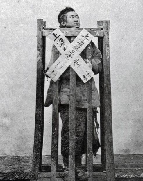 图中是晚清时期的犯人,被关在站笼里.