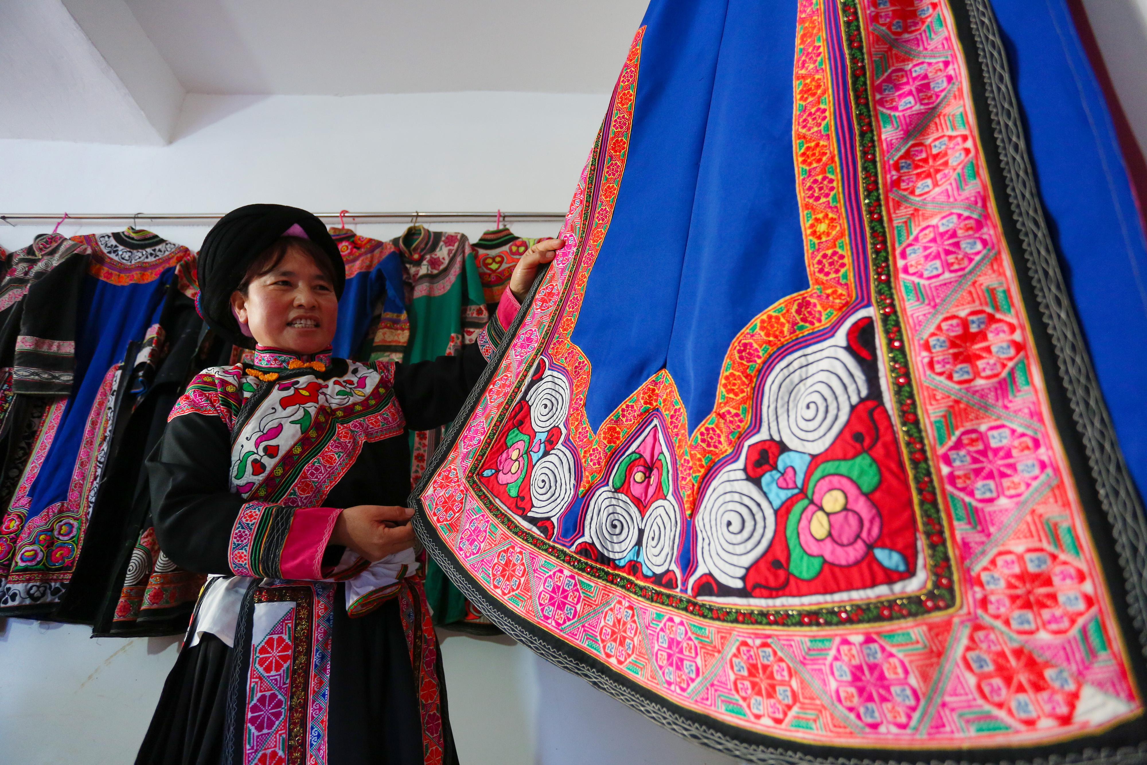 在贵州省威宁县龙场镇龙丰社区,唐柱姐在展示自己制作的民族服饰