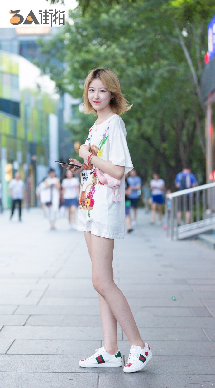 短发美女身穿白色大t,搭配休闲小白鞋,尽显白皙大长腿!