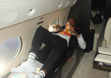 姿势如何?罗齐尔在飞机上躺着享受零食