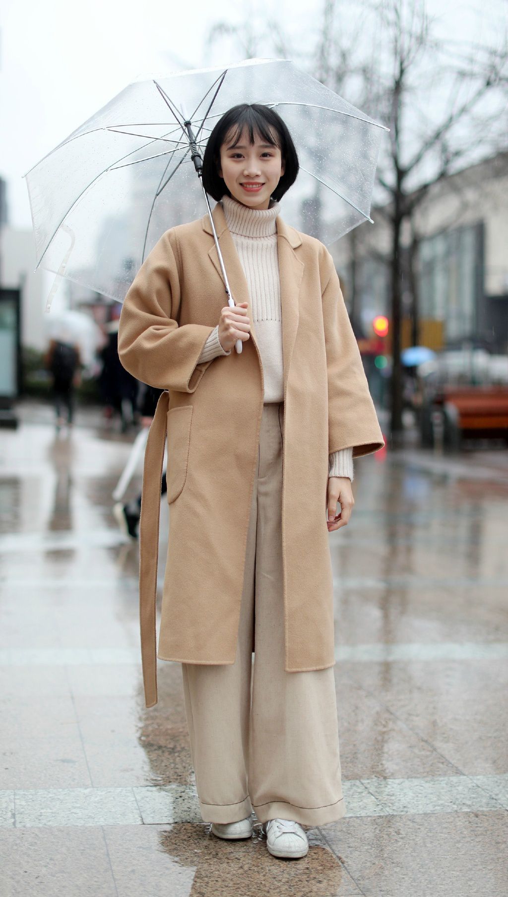 街拍:这个打着雨伞的短发女孩身穿浅色的高领的毛衣和长长的休闲阔腿