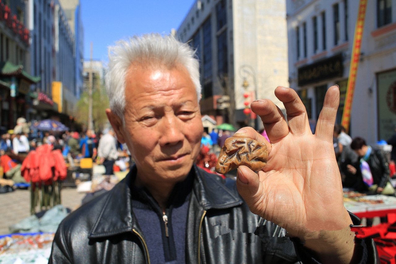 他在摊位上叫卖石头,其中这块叫卖10万,只因石上有这个字