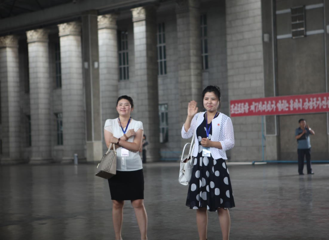 图为朝鲜平壤火车站,两名女导游正在对着游客挥手,长相也很一般.