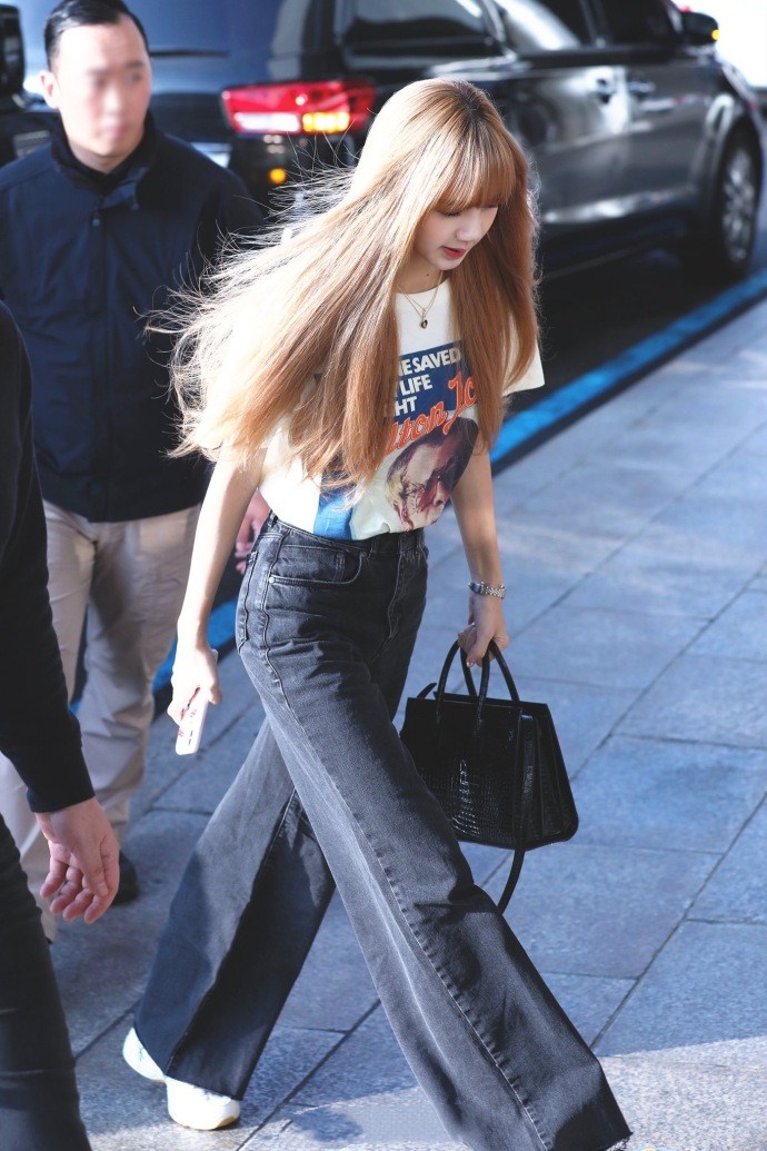 blackpink成员lisa机场街拍,简约t恤与仔裤搭配,行走的金发芭比