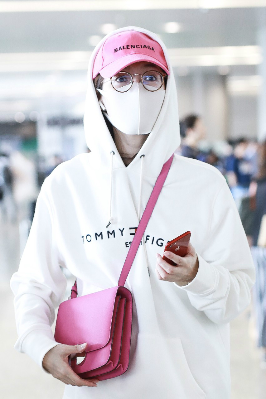 江疏影穿白色卫衣现身机场玩下衣消失,戴棒球帽和口罩遮捂好严实