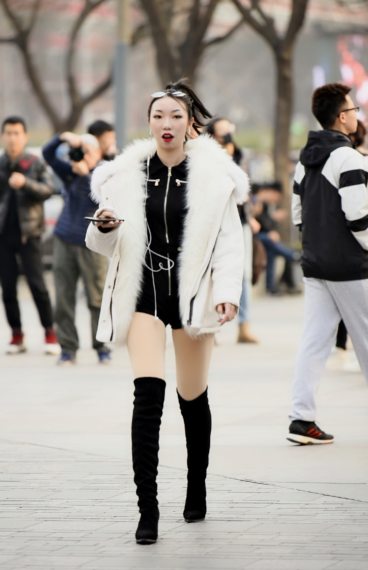 这位女孩选择黑色过膝靴,搭配黑色百褶短裙 烟灰色休闲外衣,简约舒适