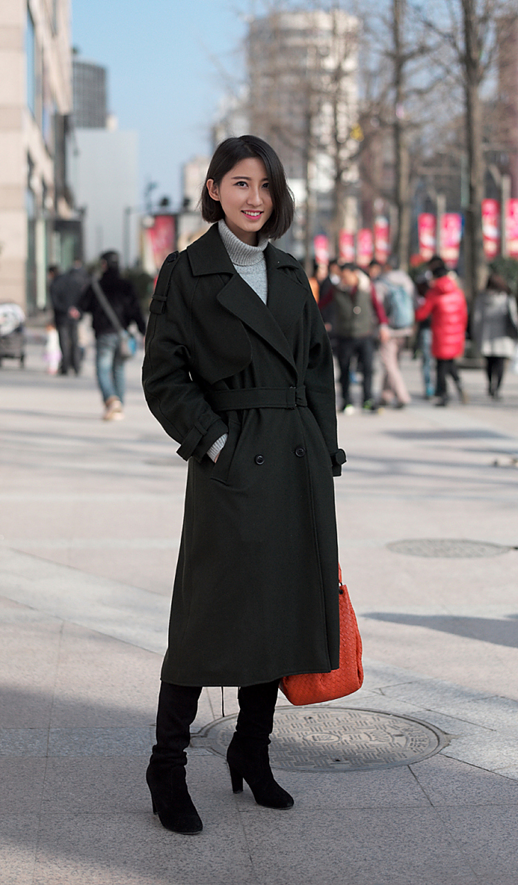 过膝的黑色毛呢大衣颇具大上海的复古气息,内搭艳丽的格子针织衫,点亮