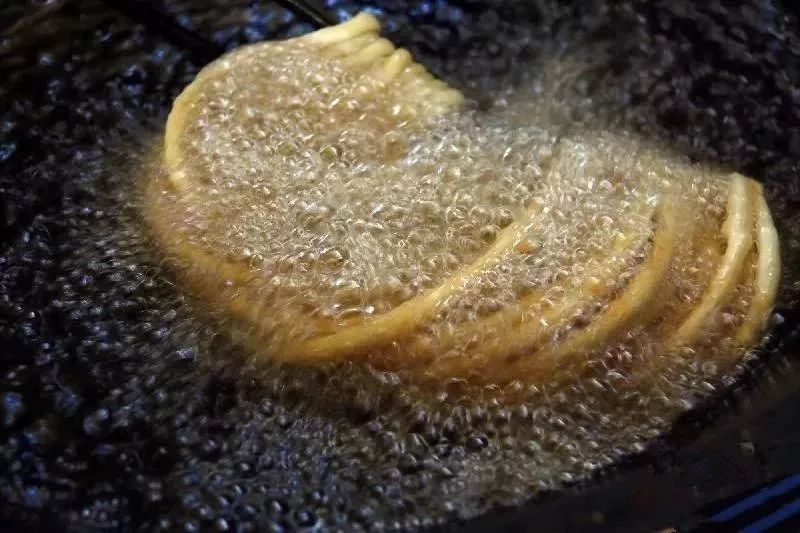 火炸,先将一头炸一会,再将另一头炸一会,然后用棒子托着将中间炸一会