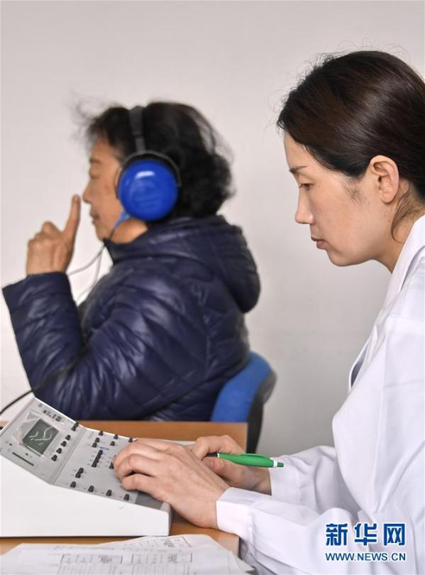 3月3日,志愿者在为北京梅源社区的老人进行听力测试.