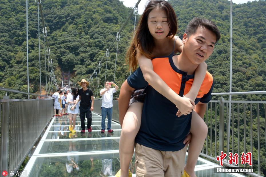广东景区现"玻霸保镖 每天平均背30名游客过玻璃桥