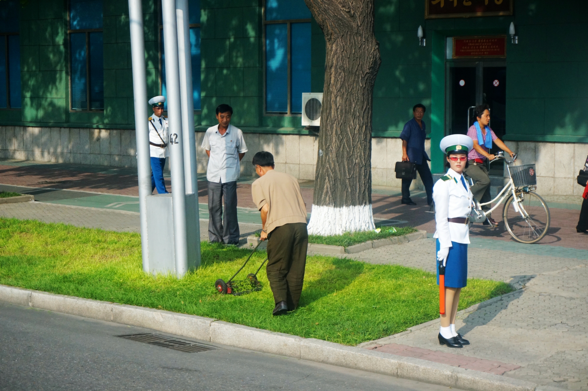 图为朝鲜平壤的马路边,一名穿着制服的朝鲜女交警在执勤.