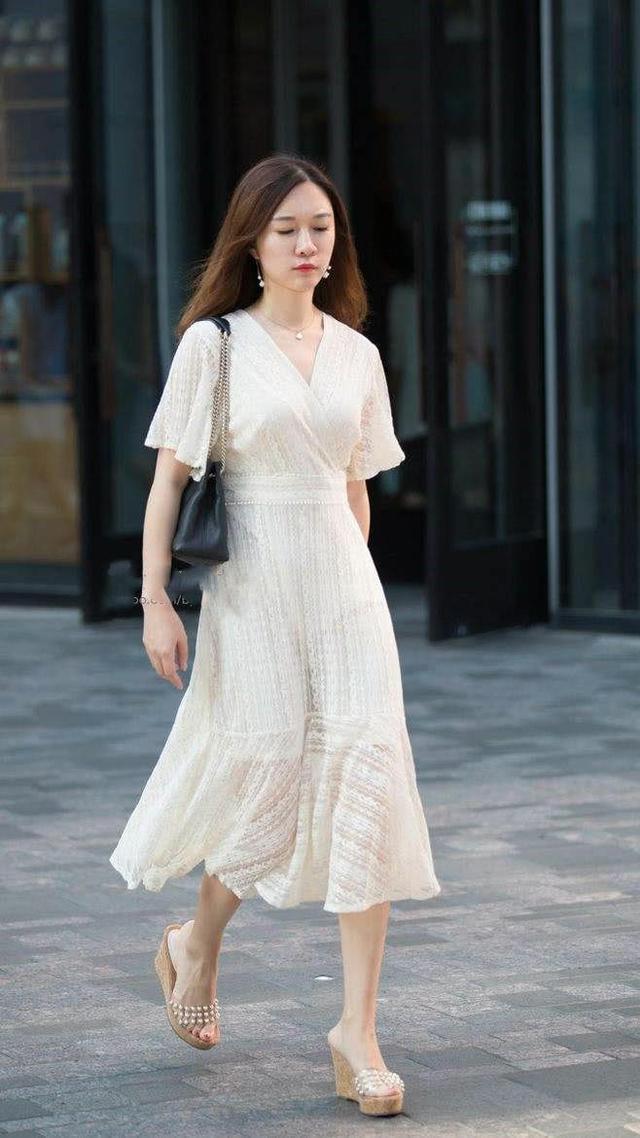 街拍:身材丰腴,皮肤白皙,一袭白色吊带镂空短裙,秀出个性风采