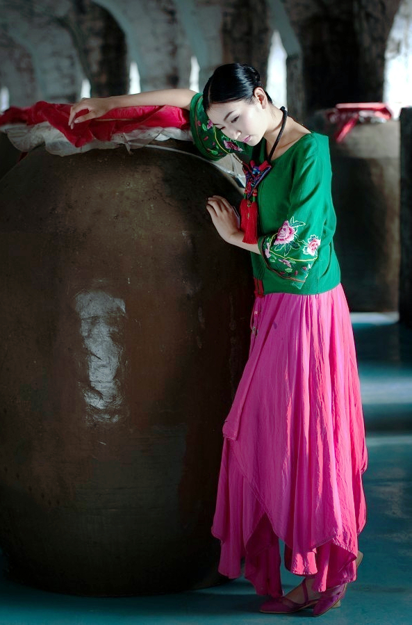 一个依偎在地窖酒坛边的民族美女