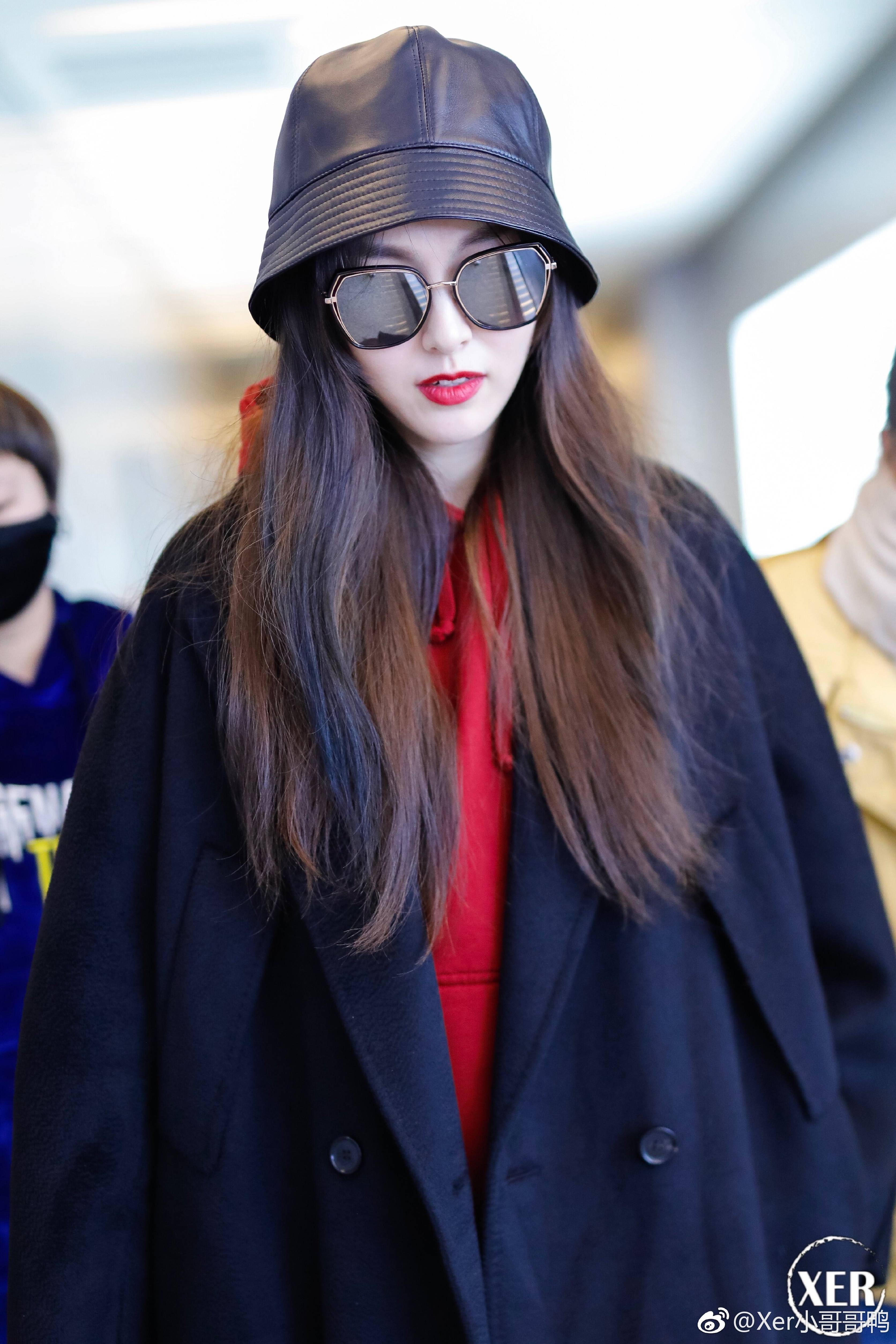 唐嫣戴渔夫帽和墨镜穿黑色长款大衣现身机场皮肤白皙